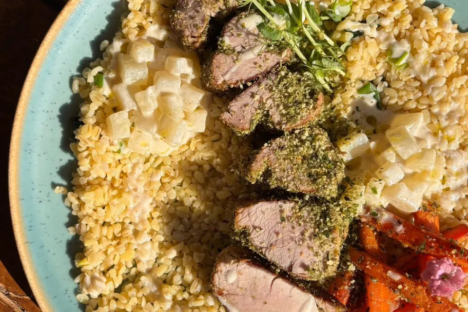 Zöldfűszeres kéregben sült sertésszűz póréhagymás bulgurral, tejszínes karalábémártással, répahasábokkal (G, L) 