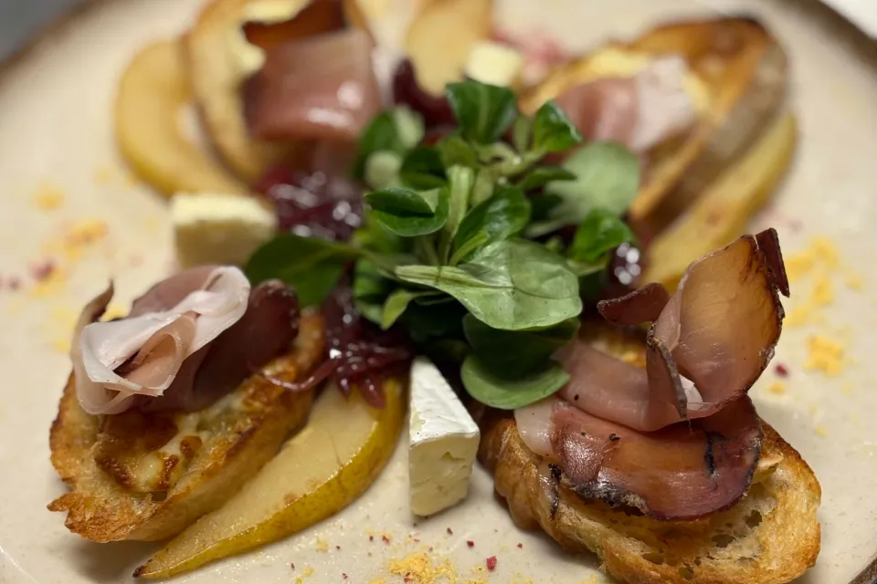 Crostini Salva Cremasco sajttal, lilahagymalekvárral, körtekompóttal, speck sonkával és madársalátával (G, L)